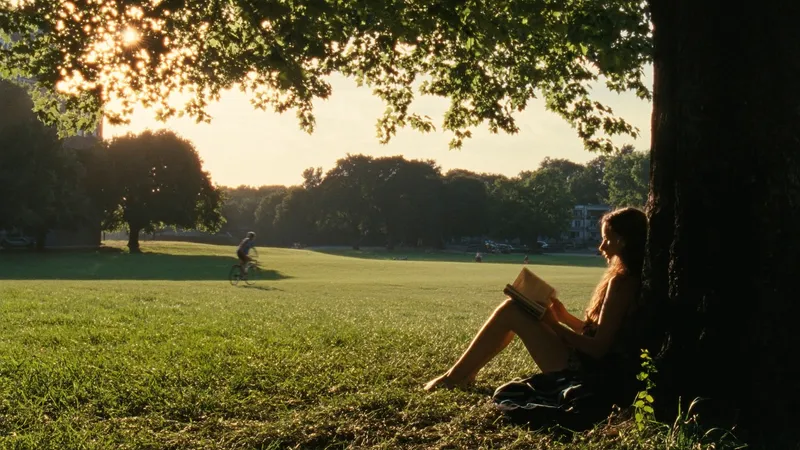 A late-afternoon slice of quiet: a young woman leans against…